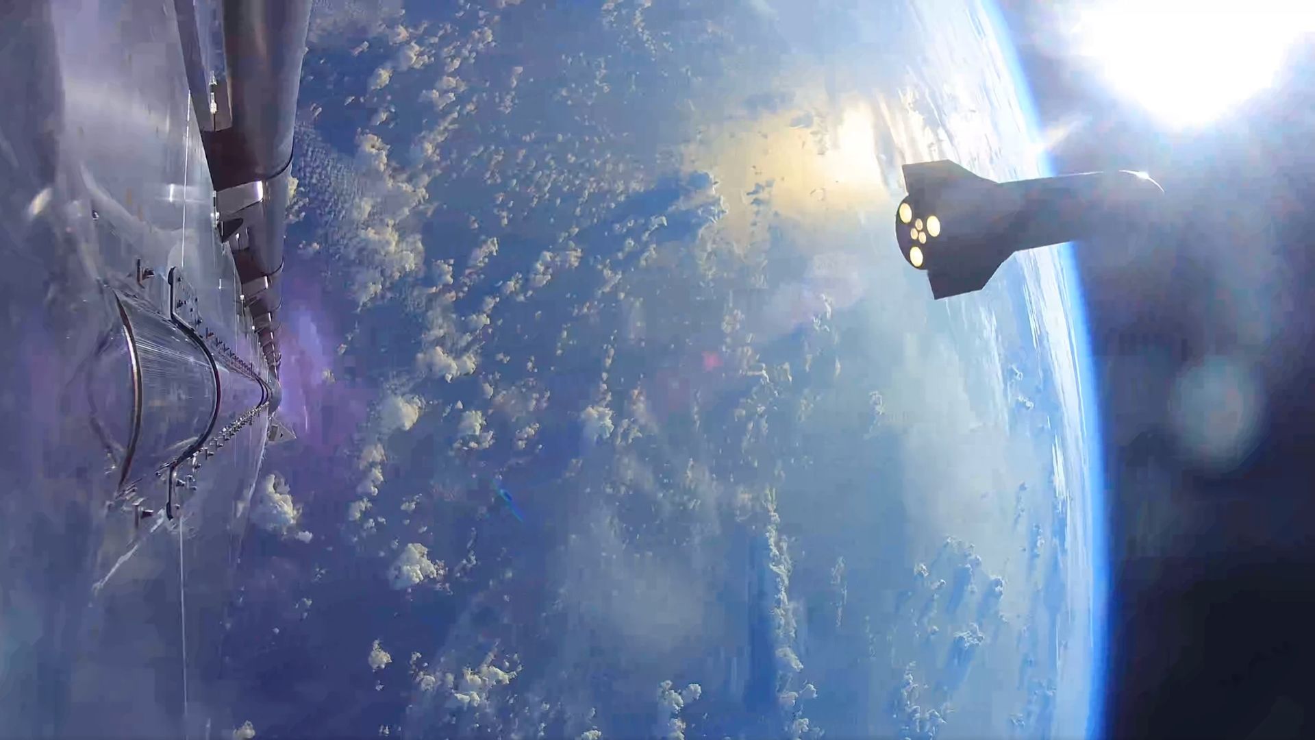 a large rocket with its six engines glowing orange is seen high above earth