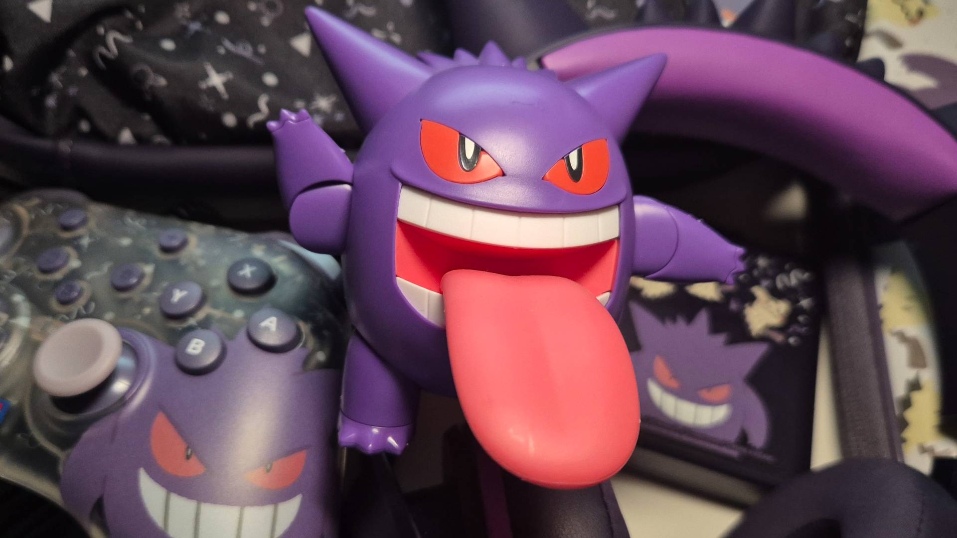Photo of a Gengar toy sitting on a pile of Razer and Hori gaming accessories.