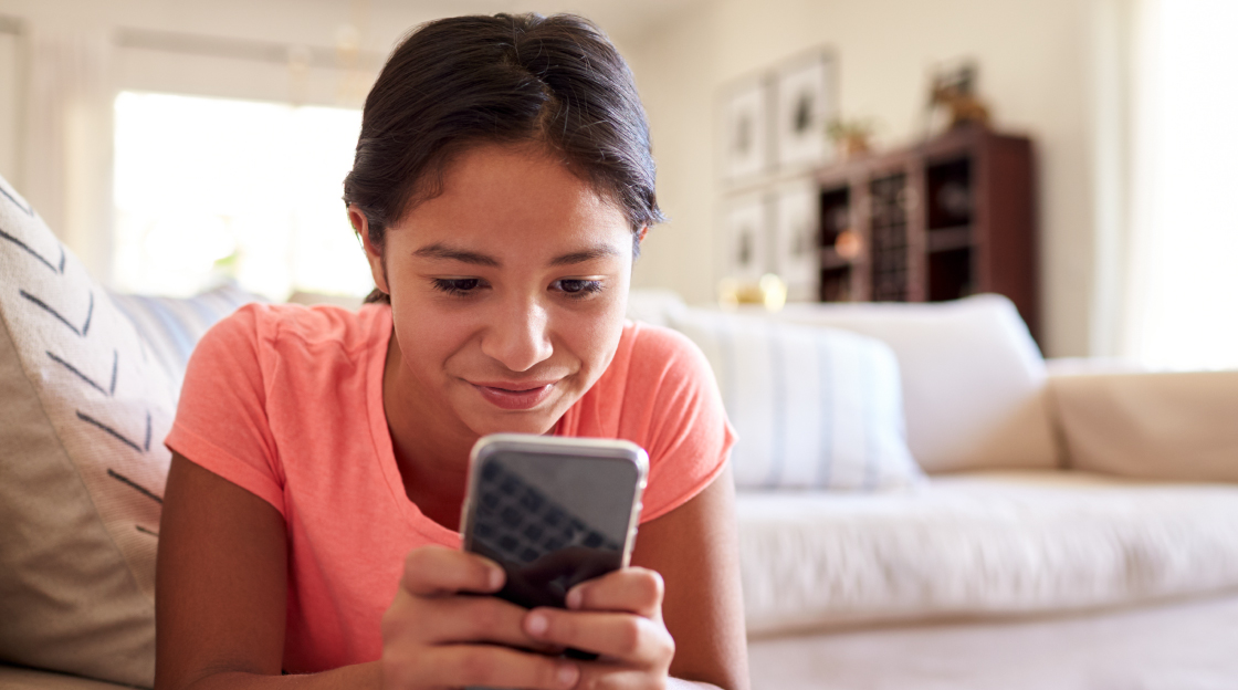 A young girl browsing on her smartphone with parental controls