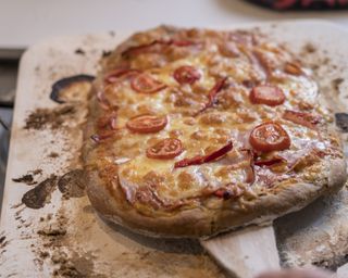 homemade pizza baking in oven, cooked on pizza stone