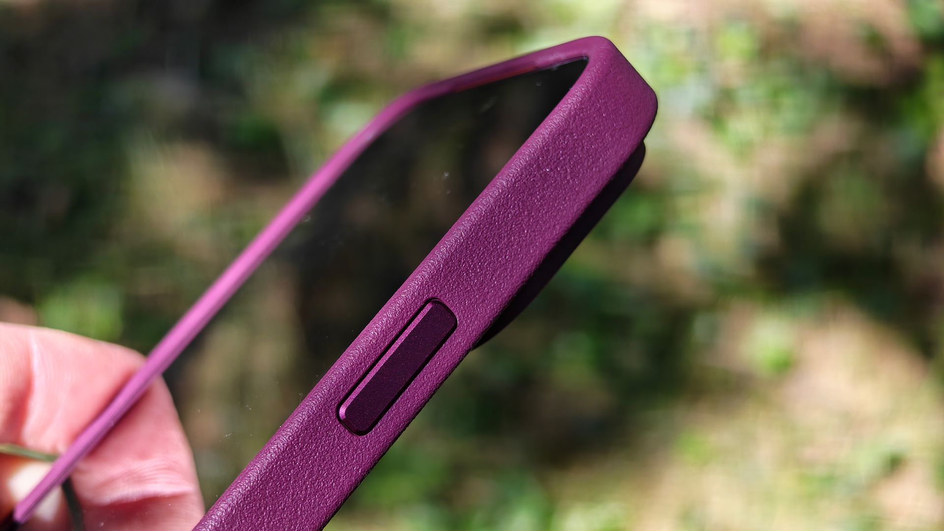 A burgundy Dbrand MNML case on an orange Apple iPhone 17 Pro Max