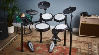 Alesis Nitro Max kit sat in front of a blue/grey wall