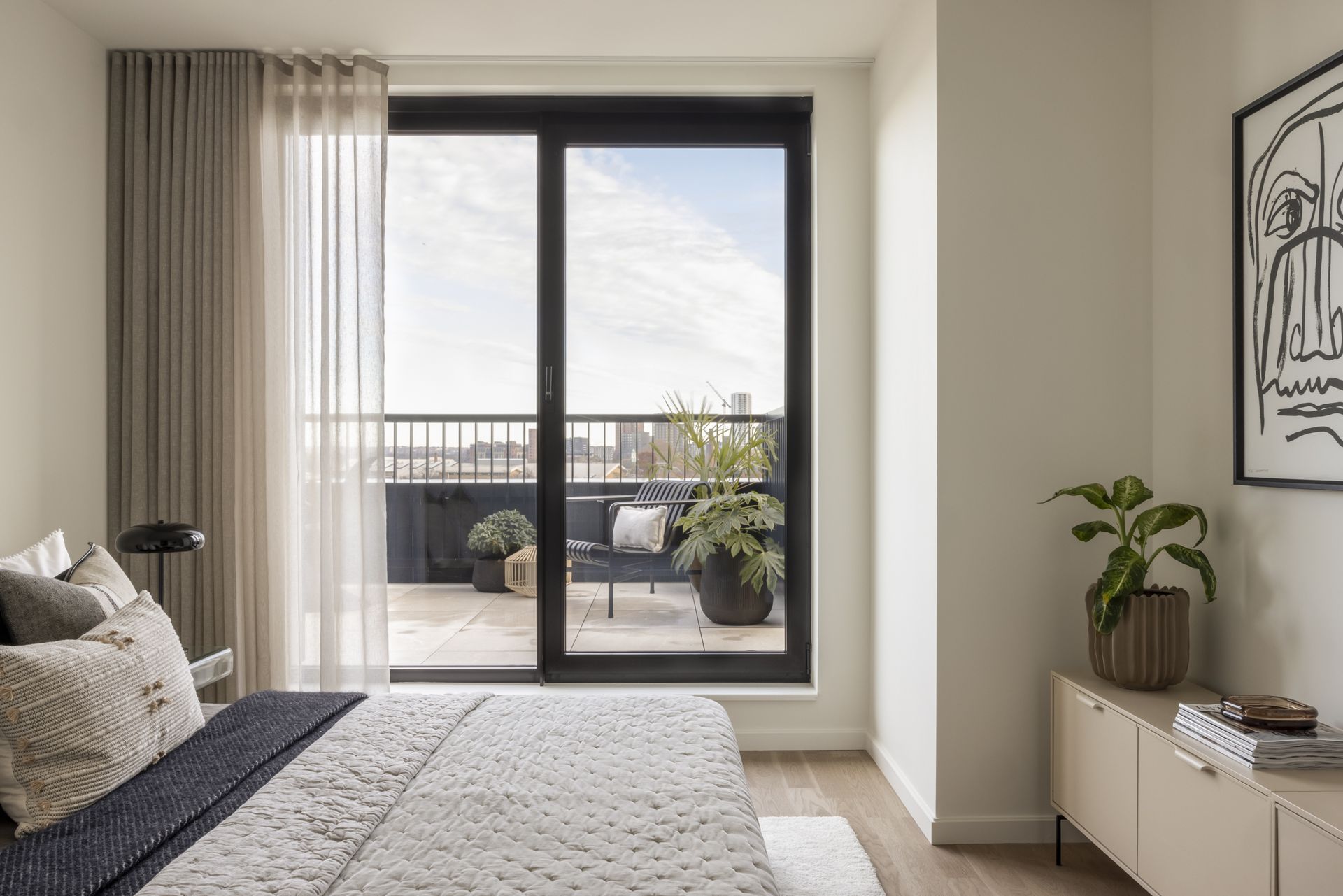 bedroom with London skyline views and cream bed cover at Vabel Lawrence Penthouse