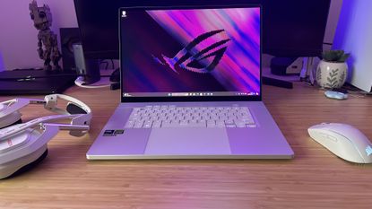 Asus ROG Zephyrus G16 gaming laptop on a desk with headset and mouse