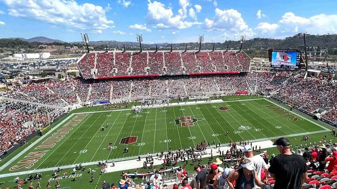 When Aztec fans head to Snapdragon Stadium in San Diego, California, this fall, they will be greeted by 19 new LED displays as Daktronics (NASDAQ-DAKT) of Brookings, South Dakota, has partnered with San Diego State University (SDSU) to design, manufacture and install the new system totaling nearly 8,400 square feet and 7.5 million pixels. Features of the stadium include local aspects to help fans feel at home in San Diego. “We are excited to partner with Daktronics, the premier scoreboard and digital board organization in the world,” said SDSU Director of Athletics John David Wicker. “We’ve always said that game-day experience is the most important piece to Snapdragon Stadium and the Daktronics video scoreboards provide fantastic displays to a stadium with great sight lines. The viewing experience at Snapdragon Stadium is now unmatched in collegiate athletics.” The new main video display measures 42 feet high by 73 feet wide to deliver more than 3,000 square feet of digital canvas for the university’s football, athletics and other special events. It is mounted in the northwest corner of the stadium. Mirroring the main display in the opposite corner of the stadium, a video display will measure approximately 26.5 feet high by 50.5 feet wide to deliver similar and supplemental information as the main display. Both displays feature industry-leading environmental protection to ensure they operate as expected in the San Diego outdoors. “We’re thrilled to be a part of this Snapdragon Stadium project and to help San Diego State deliver a local experience to their events,” said Robin Hall, Daktronics regional manager. “The displays will help to create an amazing home field advantage for the Aztecs for years to come. We are grateful to continue working with the school on their campus-wide initiative to enhance the in-person experience at all of their athletics venues as they move into the future.” The end zone video displays are each capable of variable content zoning allowing each to show one large image or to be divided into multiple zones to show any combination of live video, instant replays, up-to-the-minute statistics, graphics and animations, and sponsorship messages. All 19 displays feature 10-millimeter pixel spacing to deliver crisp, clear imagery to fans throughout the stadium. “Going from a conceptual drawing to an actual stadium is always exciting with new construction, and having a good onsite team is essential,” said Luke Tingle, Daktronics senior project manager. “Living local, I take great pride in San Diego getting a new stadium and our company delivering state-of-the-art displays to help bring it to life for this community.” The stadium also features two large ribbon displays mounted to the seating fascia. One measures approximately 2.5 feet high by 420 feet in length and the other measures 2.5 feet high by 400 feet long. Nine additional ribbons measure 2.5 feet high and combine for 290 linear feet while five more ribbon style displays measure 6 feet high and combine for 167 linear feet. These displays work together to deliver additional graphics and animations as well as providing opportunities to highlight sponsors throughout events. Creating a complete street-to-seat experience, a marquee display is installed outside the stadium to connect with fans and audiences as they arrive for the main event. This display measures 13 feet high by 23 feet wide to brand the experience, promote upcoming events and deliver sponsorship recognition. Daktronics included its powerful Show Control solution with this installation. This industry-leading system provides a combination of display control software, world-class video processing, data integration and playback hardware that forms a user-friendly production solution. For more information on Show Control, visit www.daktronics.com/show. In addition to the equipment installation, San Diego State University will receive a content package to be produced and delivered by Daktronics Creative Services.