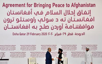 US Special Representative for Afghanistan Reconciliation Zalmay Khalilzad and Taliban co-founder Mullah Abdul Ghani Baradar shake hands after signing a peace agreement.