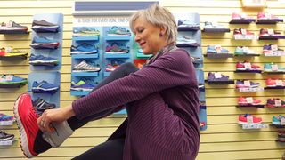 Older woman trying on running sneakers in shop