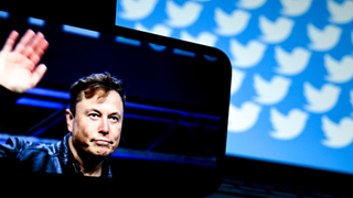 Phone screen shows Elon Musk waving