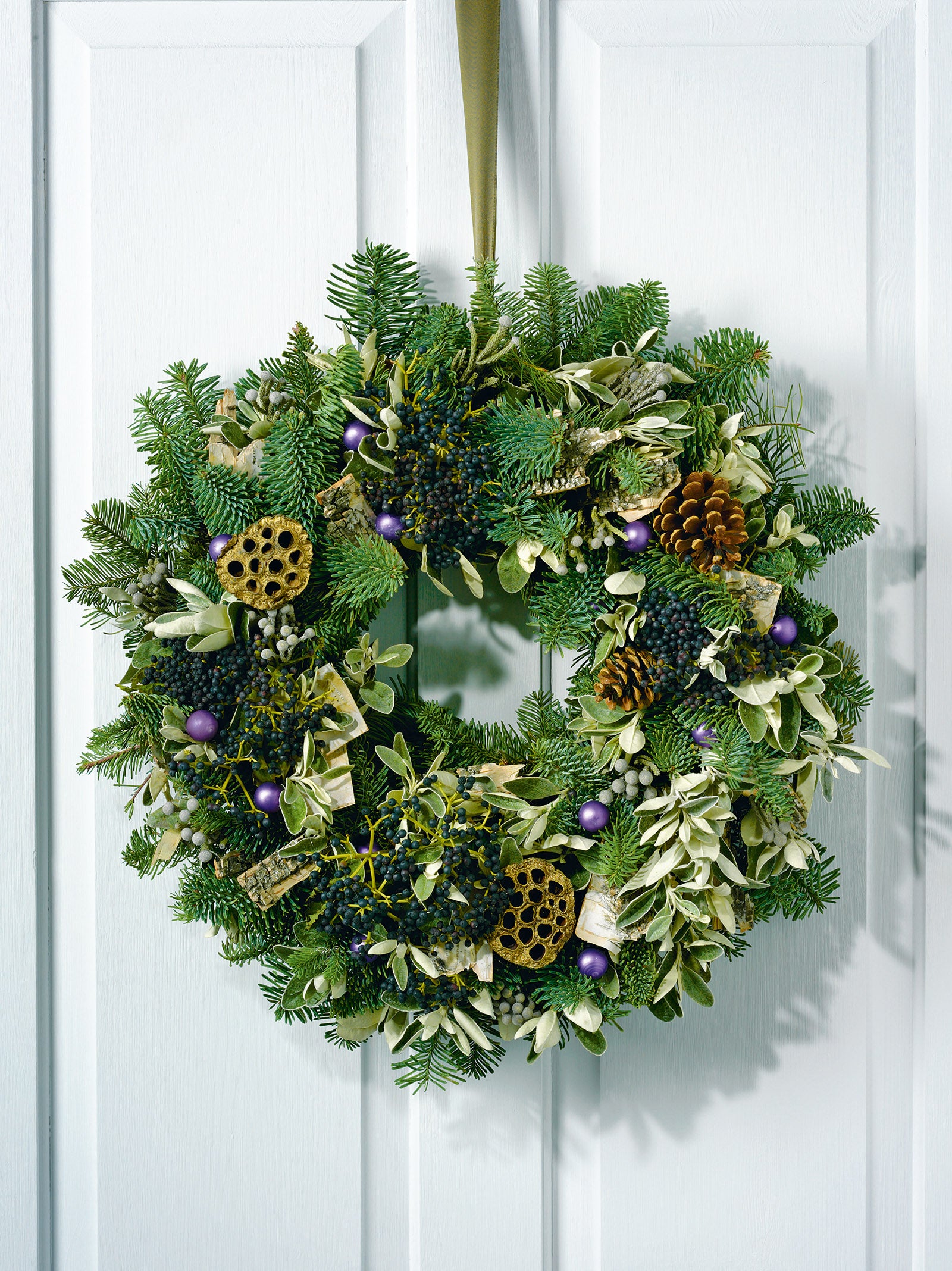 Fir and sage wreath with bark, pinecones, lotus heads, berries and baubles.