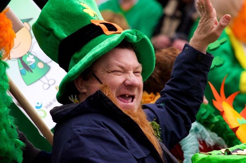 An unidentified man in a St. Patrick&#039;s Day parade waving at the crowd wearing a green leprechaun hat and laughing March 17, 2012, Cork, Ireland. 