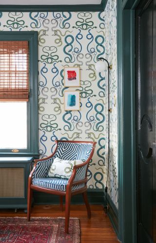 Corner of a room with white and green wallpaper and woodwork painted in teal