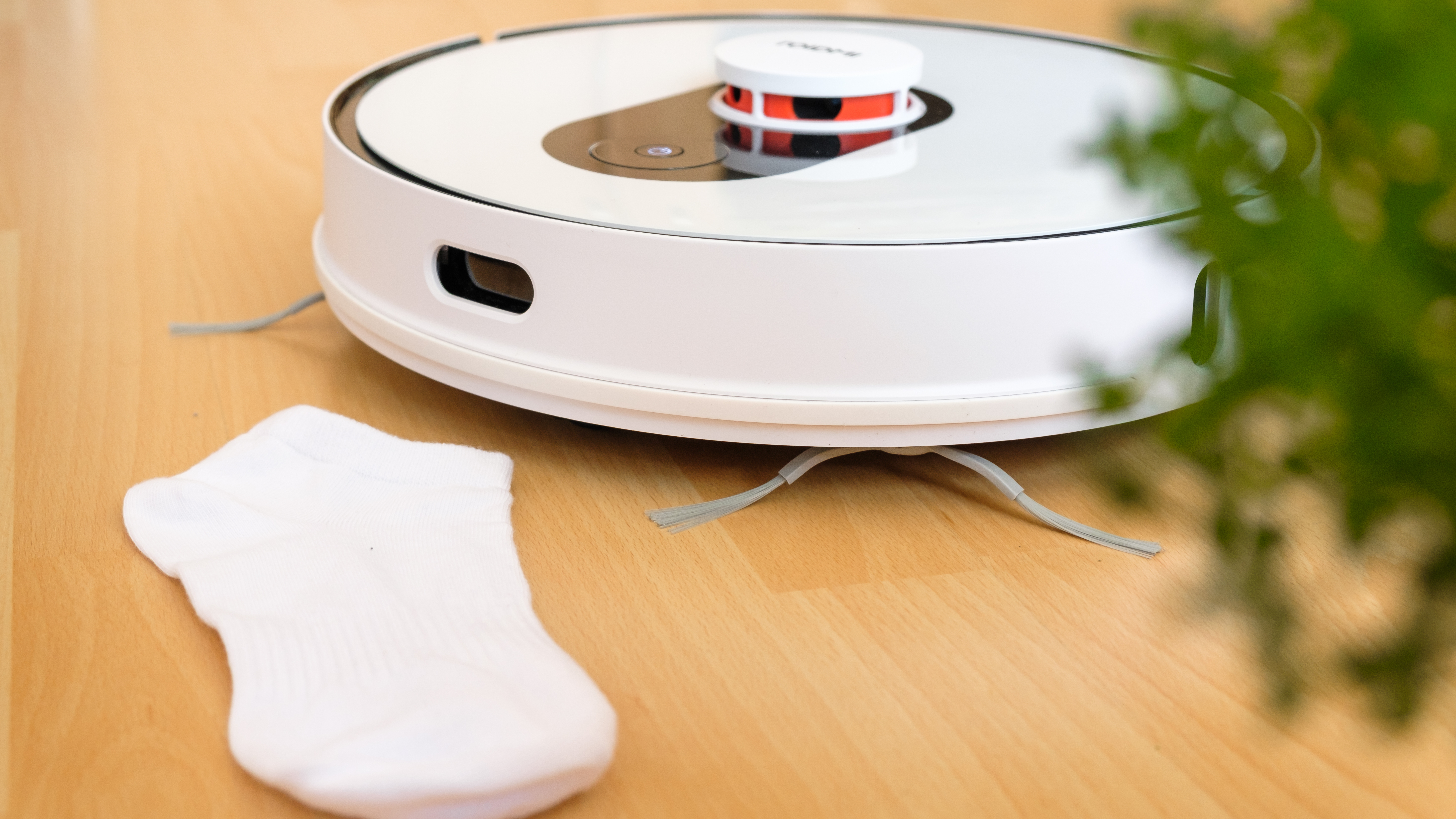 Robot vacuum next to child&#039;s white sock