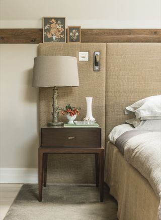 bedside table, side of bed and upholstered headboard