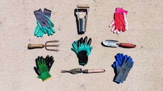 Best gardening gloves laid on the ground with garden tools
