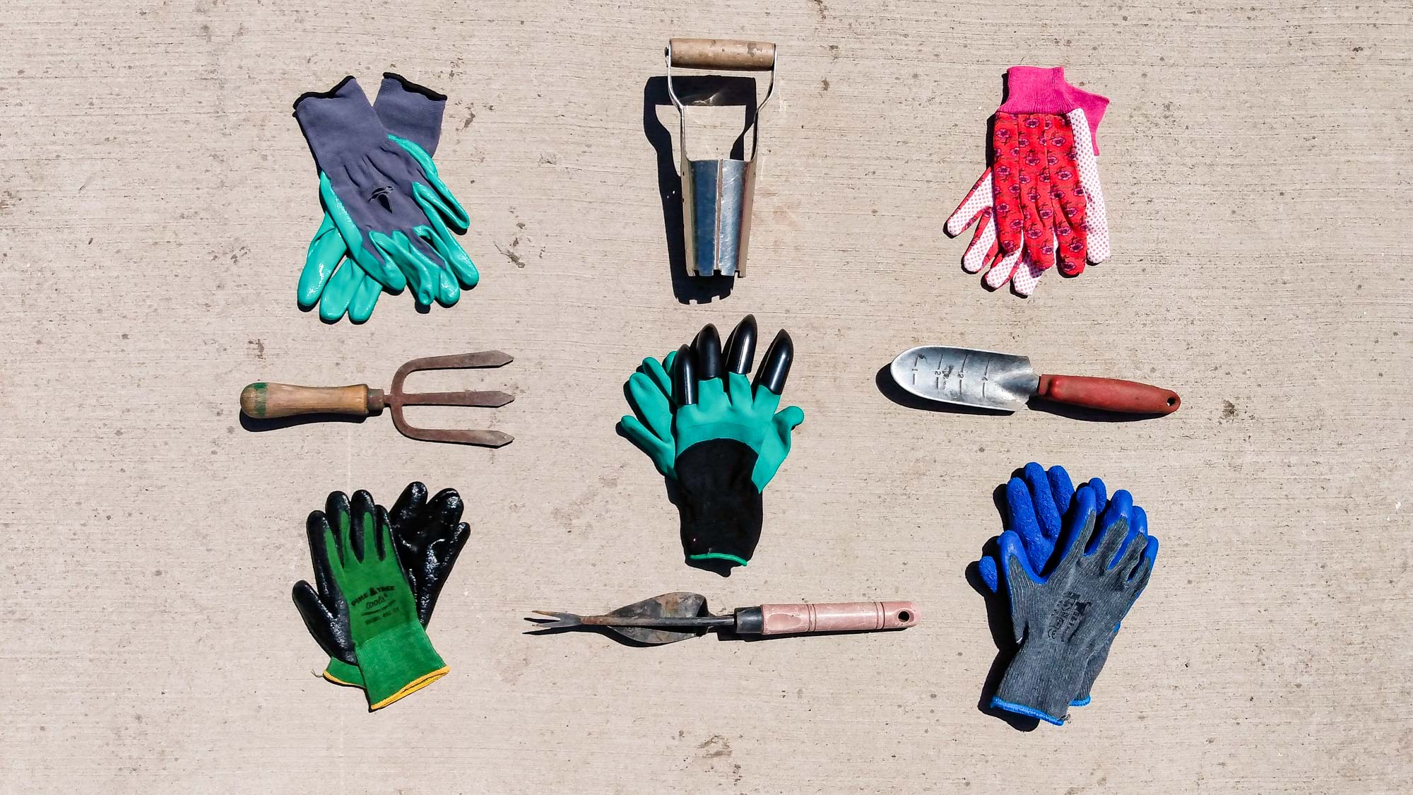 Best gardening gloves laid on the ground with garden tools