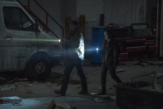 (L to R) Pedro Pascal (as Joel) and Bella Ramsey (as Ellie) walk by a car in HBO's The Last of Us episode 4