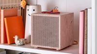 A pink IKEA Badkruka Bluetooth speaker nestled into a shelving unit 