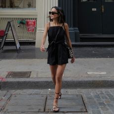 fashion influencer @linhniller in New York wearing a black summer outfit from Madewell with strappy flat sandals and knotted leather crossbody bag