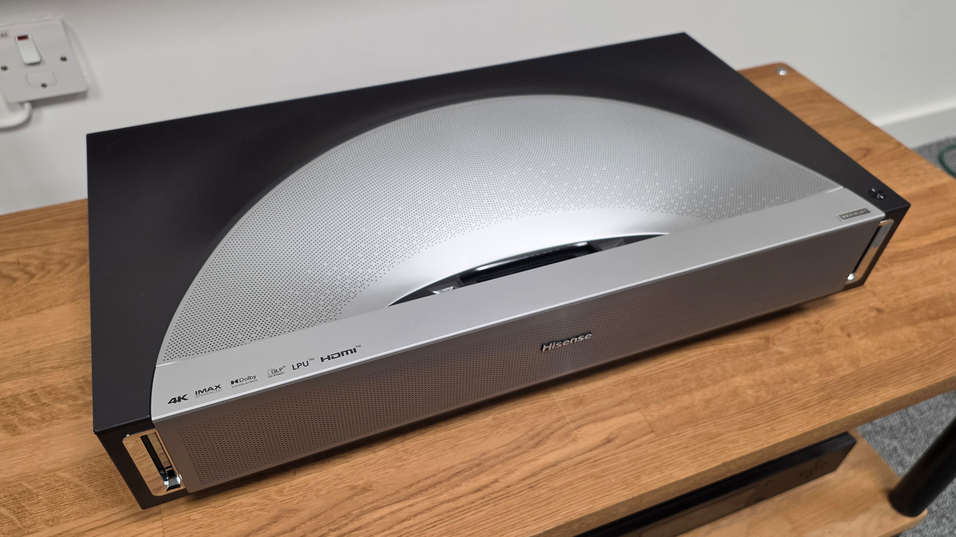 Hisense PX4 Pro UST projector on wooden AV rack