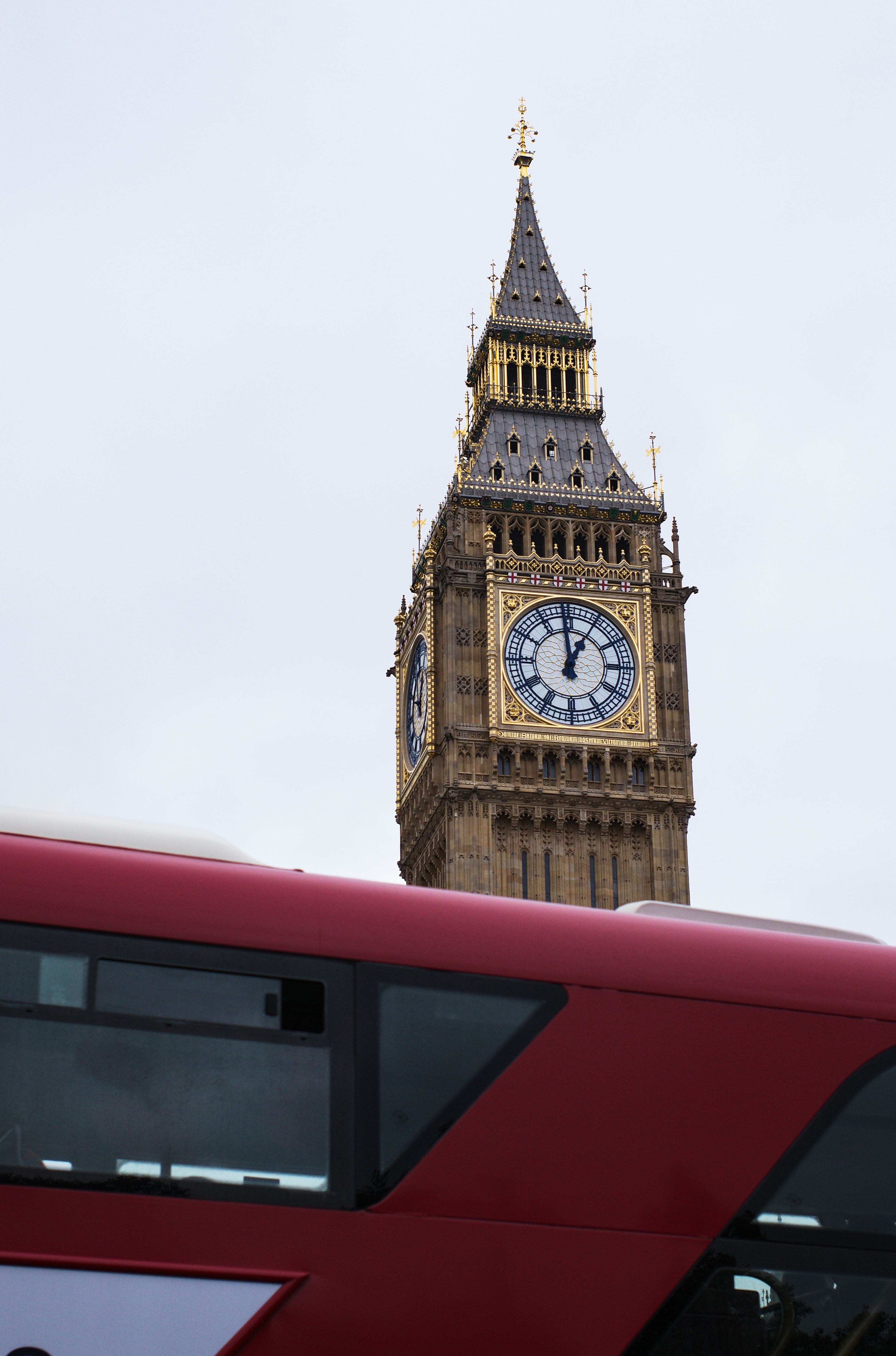 A red bus passing in front of Big Ben