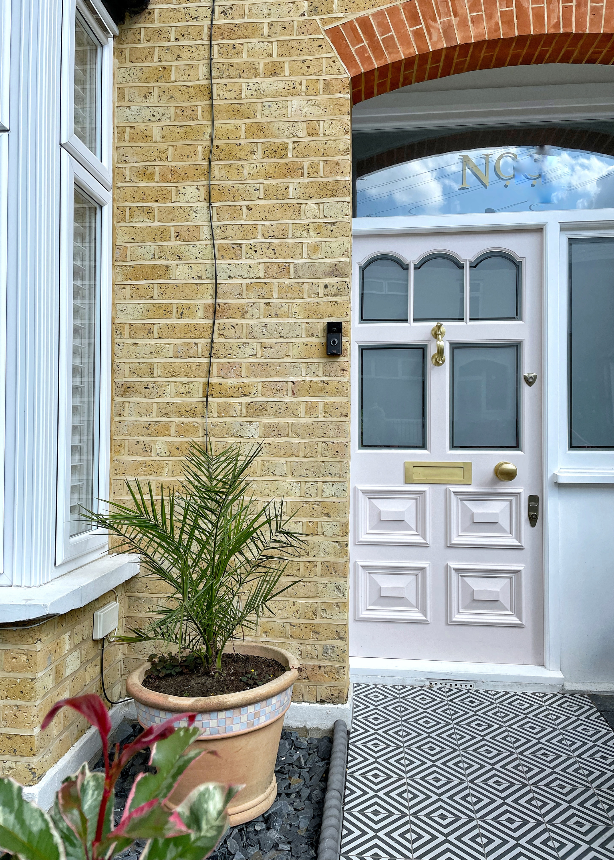 clean brickwork on a victorian home with a pink painted front door