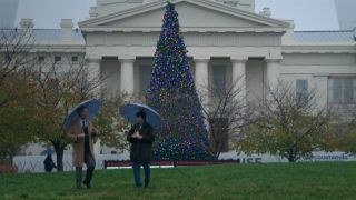 Two characters carrying umbrellas in front of the Old Courthouse in St. Louis in Soul on Fire