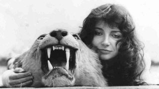 Kate Bush posing for a photograph with a lion’s head in the late 1970s