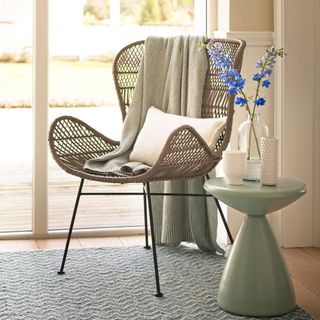 reading area with sleek side table and arm chair with flower vase