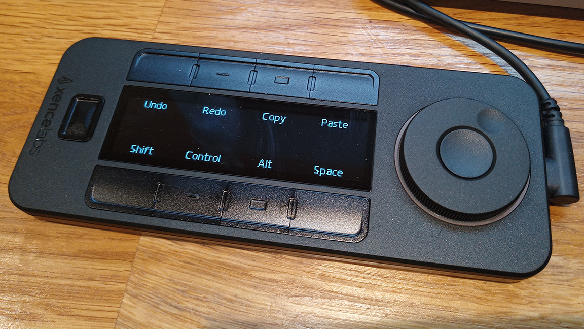 Xencelabs Pen Tablet Liten recension;  en svart låda med knappar och en radiell urtavla på ett träbord
