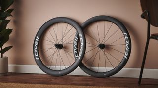A pair of Roval Rapide CLX II road bike wheels leans against a terracotta wall
