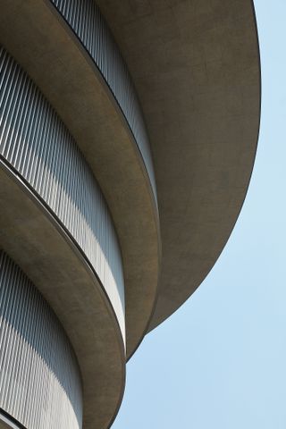 A closer look at the exterior of the He Art Museum. We see the top part of the circular building in gray concrete.