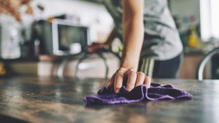 picture of woman cleaning dining table in kitchen