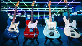 Four Fender guitars, stood against a colorful background