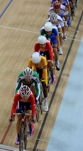 The men's points race field is strung out single file.