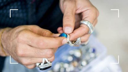 woman holding a piece of jewelry in an attempt to do jewelry repairs