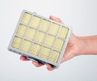 Someone holding an extra large, rectangular HEPA vacuum filter