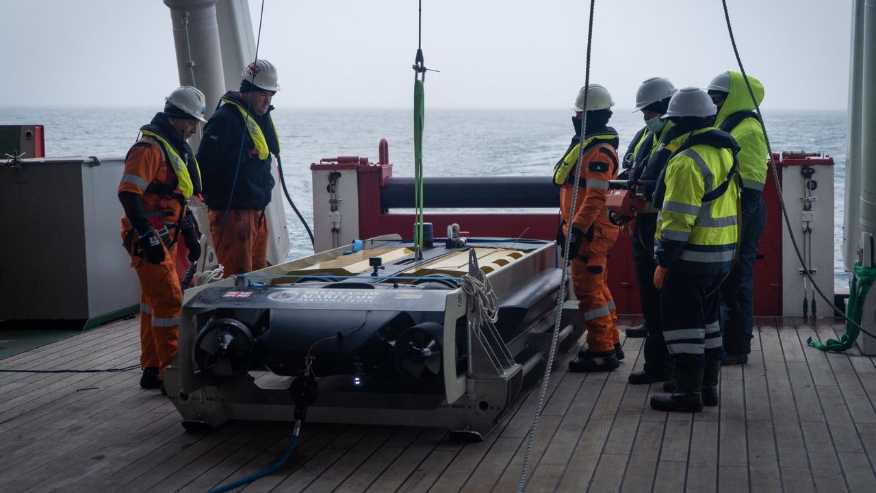 Crew members prepare the Sabertooth underwater vehicle.