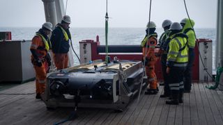 Crew members prepare the Sabertooth underwater vehicle.
