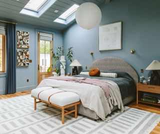 bedroom with blue walls, skylights, double bed with cozy bedding