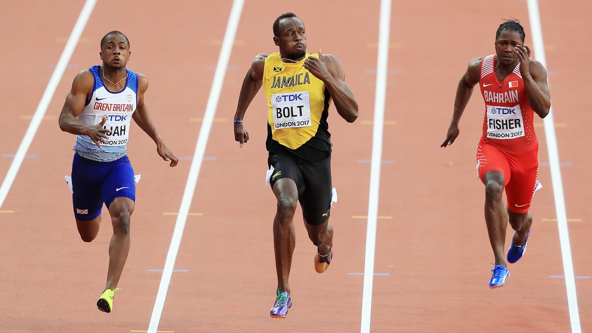 Three men sprint on a track