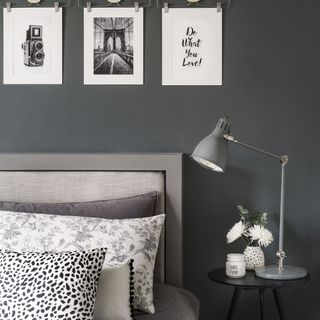 bedroom with grey wall and bed with pillows and bedside table