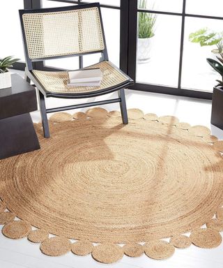 A circular shaped jute rug next to an armchair.