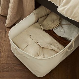 H&M Large lidded storage basket under a bed containing folded clothes