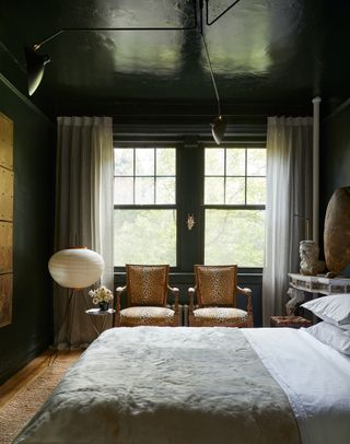 A dark green bedroom with two leopard print chairs