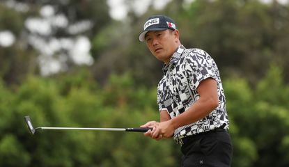 Ryutaro Nagano watches his putt with a putter in hand