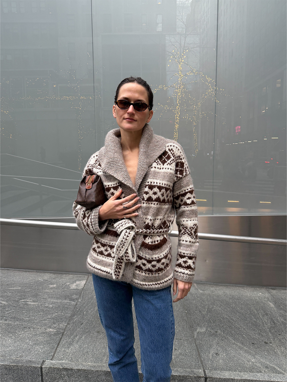 Eliza Huber wearing the Doen Hale Cardigan with jeans and a brown Celine clutch bag.