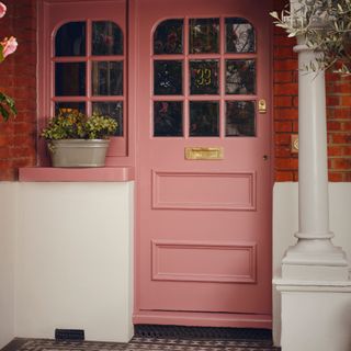front door colour mistakes, front door painted pink with matching window, red brickwork, planter, off-white painted masonry and pillar
