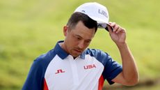 Xander Schauffele takes off his cap at the Olympics