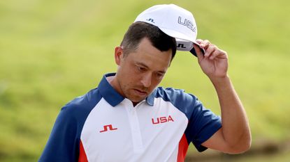 Xander Schauffele takes off his cap at the Olympics