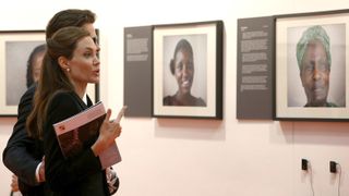 Brad Pitt and US actress and UN special envoy Angelina Jolie look at some of the art work on show at the Global Summit to end Sexual Violence in Conflict at ExCel on June 12, 2014 in London, England.